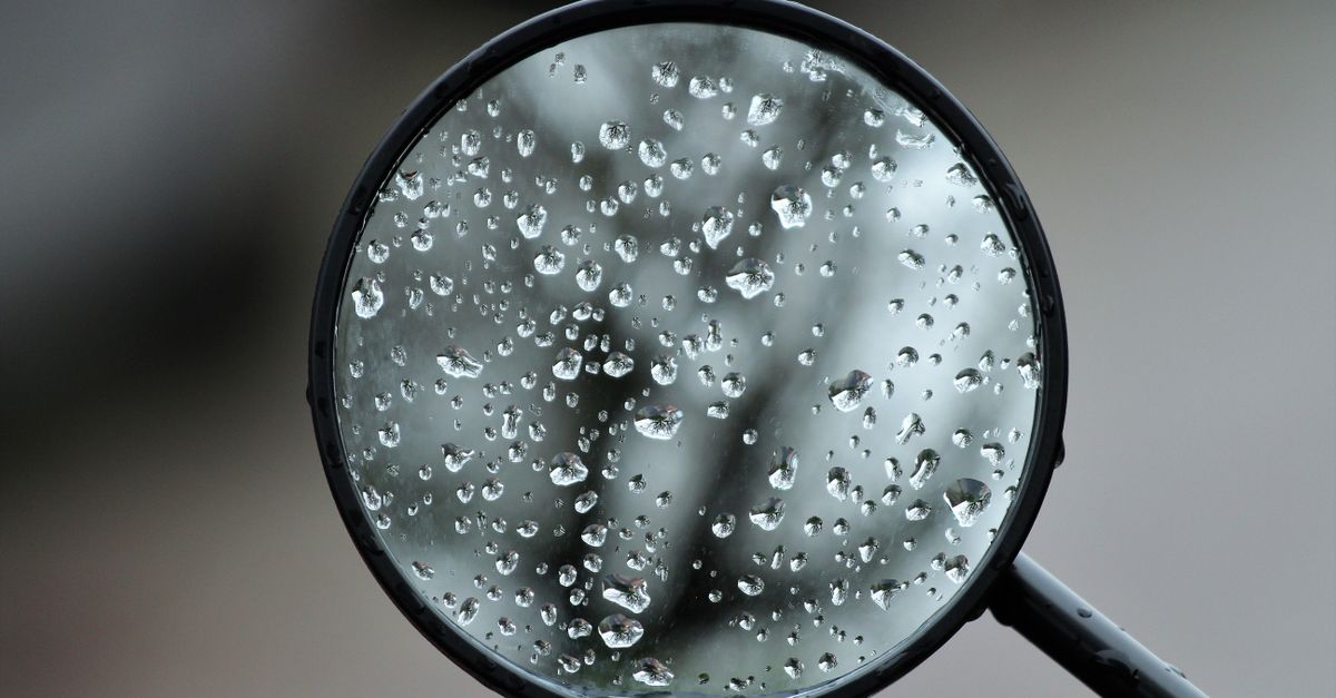 espejo lateral del auto cubierto de gotas de lluvia